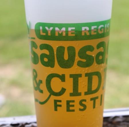 Plastic pint glass filled with cider and the festival logo