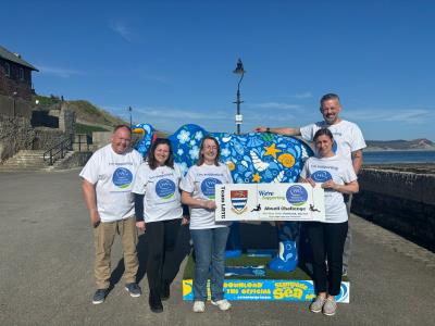 town council abseil challenge team, standing by a stamped by the sea elephant sculpture