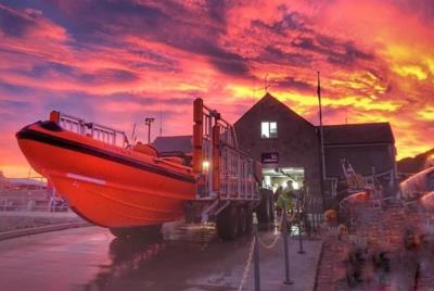 Lyme Regis Lifeboat outside the lifeboat station at sunset