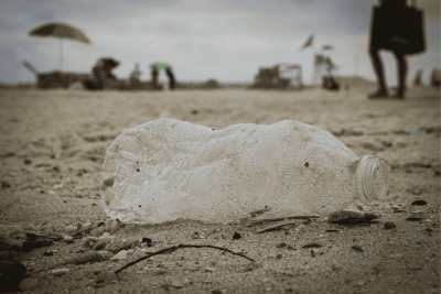a plastic bottle lying in the sand on a beach 