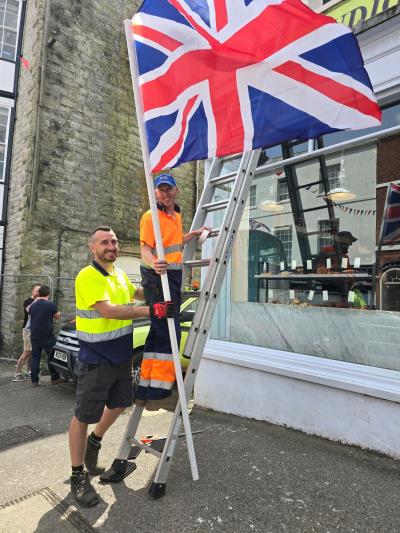 Town Council staff on ladder with Union Jack flag