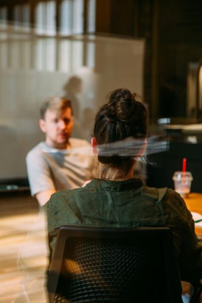 a photo of two people talking in a meeting room