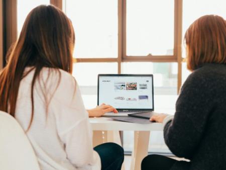 two people sat in front of a computer looking at the screen together