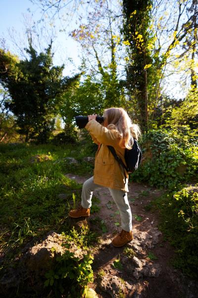 girl exploring the forest with binoculars