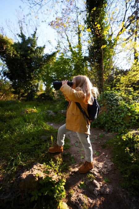 girl exploring the forest with binoculars