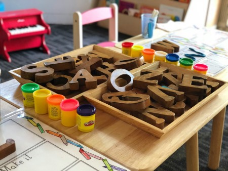 wooden building blocks and playdough on a nursery school table