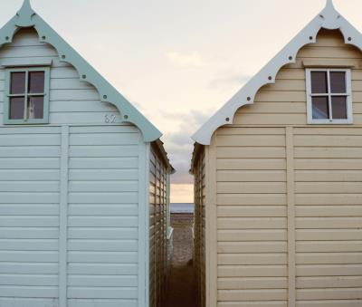 two beach huts against sunset