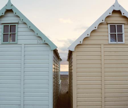 two beach huts against sunset