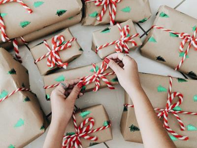 a pile of Christmas presents with a hand leaning in to grab one