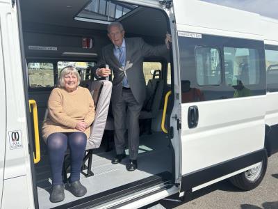 an image of a bus with the door open and two Lyme Regis councillors sat inside including the mayor