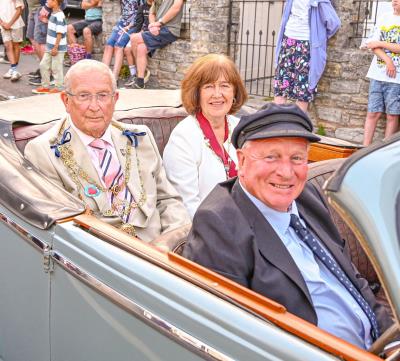 Mayor and mayoress lead the Lyme Regis carnival procession in vintage car