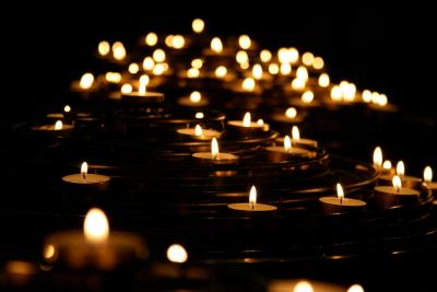 many candle flames burning bright in darkness