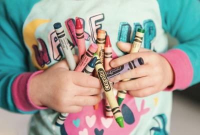 a photo of a childs hand holding a handful of crayons