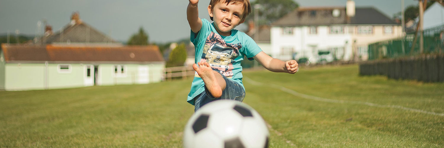 Boy kicking football